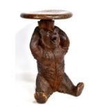A good late 19th century Black Forest carved bear adjustable stool, the seated bear with arms raised