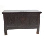 A 17th century oak coffer with hinged lid inscribed '1661' beside a tulip enclosing a candle box