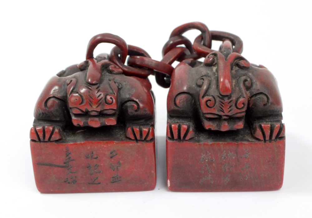 A Chinese carved hard stone double seal, each square section decorated with a carved mythical beast,