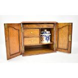 An oak smoker's cabinet with ceramic jar and two jars to interior, 25 x 28cm.