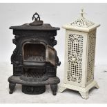Two cast iron foliate motif stoves, the cream example height approx 100cm, with various parts and