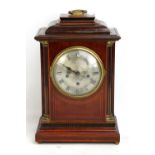 An early 20th century mahogany cased mantel clock, the silvered dial set with Roman numerals, the