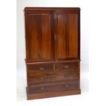 An Edwardian mahogany linen press, the upper section with two doors enclosing slides above a base of