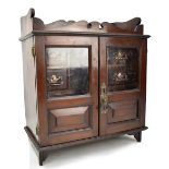 A tabletop smoker's cabinet with twin glazed doors enclosing four small drawers, 48 x 42cm.