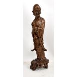 A c1900 Chinese carved root wood figure of an Immortal holding a fruit in left hand and raised on