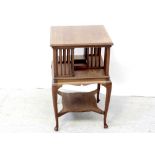 An Edwardian walnut bibliotheque tournavis supported on swept cabriole legs united by a shelf