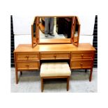 A G-Plan teak dressing table with triptych swing mirror above a central frieze drawer flanked on