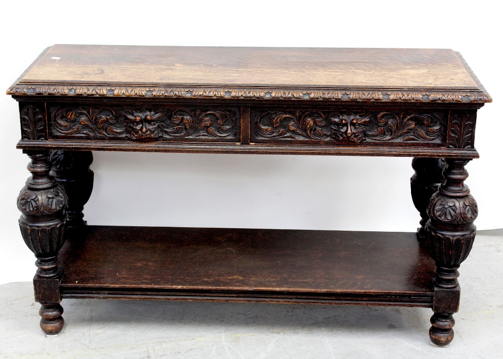 An early 20th century carved oak green man buffet with two frieze drawers supported on bulbous