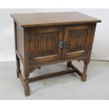 An 'Old Charm' late 20th century oak linen-fold two-door cabinet on turned legs with H-stretcher,