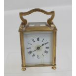 A small brass French carriage clock with white enamelled rim and dial, height 9.5cm.