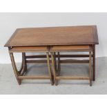 A nest of three mid-20th century teak G-Plan tables comprising one large coffee table,