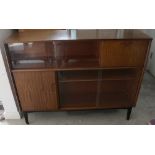 A mid-20th century floor-standing bookcase with narrow double glazed doors and fall-front cupboard