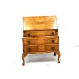 A mid/late 20th century walnut bureau with Quarter-matched fall opening to reveal compartments and