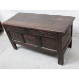 An early 18th century oak panel chest with plank top and wirework loop hinges,