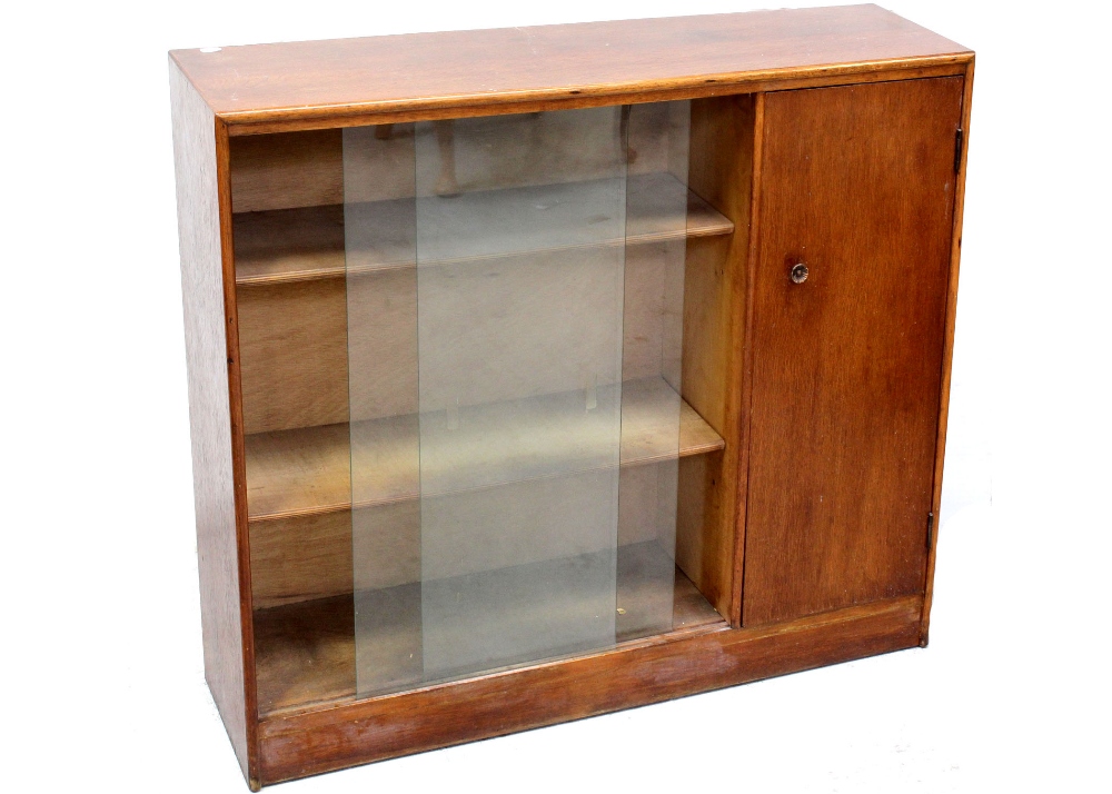 A small mid-20th century oak Heals-style floor-standing bookcase with twin sliding glass door