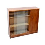 A small mid-20th century oak Heals-style floor-standing bookcase with twin sliding glass door