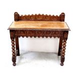 A late Victorian heavily carved oak side table with galleried back and supported on bobbin-turned