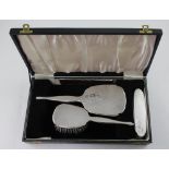 A George V case hallmarked silver dressing table set, hand mirror,