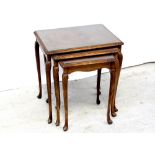 A nest of three mid/late 20th century walnut and stained beech occasional tables on cabriole legs,