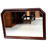 A modern stained mahogany overmantel mirror with canted corners, width 103.5cm.