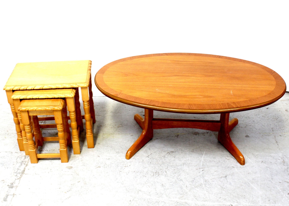 A nest of three light beech occasional tables and an oval coffee table on twin pillar supports,