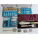 A cased set of fish servers, three matching cased sets of flatware to include berry spoons,