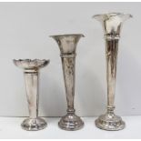 Two hallmarked silver trumpet vases, marks rubbed and one white metal trumpet vase (all af) (3).