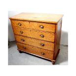 A Victorian bird's-eye maple chest of four long drawers to squat baluster supports,