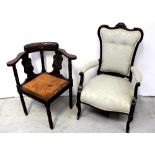 An Edwardian armchair with carved curved top rail to outswept arms,