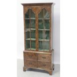 A late 19th/early 20th century mahogany display cabinet, stepped frieze over twin glazed doors,