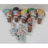 Six early 20th century ceramic bottle stoppers in the form of clown heads and two German dolls'