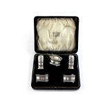 A cased set of hallmarked silver cruets to include two salts, mustard pot, pepper pots,