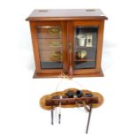 A mahogany glazed twin door smoker's cabinet with numerous accessories and pipes, height 35cm, and a