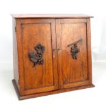 An oak table top stationery cabinet, the two drawers with carved leaf and berry detail enclosing