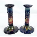 MOORCROFT; a pair of tubeline decorated 'Finches' candlesticks with impressed marks to base,