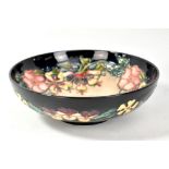 MOORCROFT; a floral tubeline decorated footed bowl on navy ground, impressed marks and year cipher
