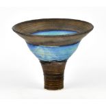 EMMANUEL COOPER (1938-2012); a stoneware stem cup with mottled turquoise glaze and bronze rim and