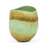 JOHN WARD (born 1938); an oval stoneware vessel with wavy rim covered in mottled green glaze,