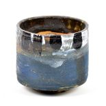 ROBIN WELCH (born 1936); a stoneware yunomi covered in matt blue glaze with black and white rim,