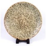 A large shallow stoneware dish decorated with a web pattern, incised mark, diameter 43cm.