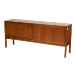 A 1960s teak sideboard with panel sliding doors enclosing drawers and sectioned interior, raised