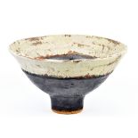 ROBIN WELCH (born 1936); a stoneware pedestal bowl covered in white and bronze glaze with red