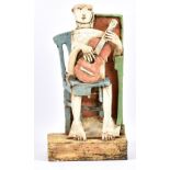 CHRISTY KEENEY (born 1958); a flattened earthenware sculpture of a seated guitar player,