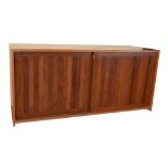 A 1960s teak music centre cabinet having two panel sliding doors enclosing a fitted interior with