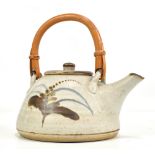 Lowerdown Pottery; a stoneware teapot with cane handle, foxglove decoration on pale grey ground,