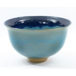 A Japanese footed bowl covered in turquoise glaze with indigo rim, impressed mark, diameter 22cm.