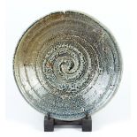 LISA HAMMOND (born 1956); a salt glazed dish with spiral decoration to well, diameter 34.5cm. (D)