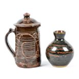 Wenford Bridge Pottery; a stoneware jug and cover, tenmoku glaze with incised decoration,