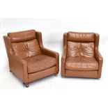 A pair of 1970s tan leather wing back easy chairs.