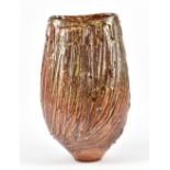 ALEX SHIMWELL (born 1980); a tall textured stoneware vase covered in shino and ash glaze with iron